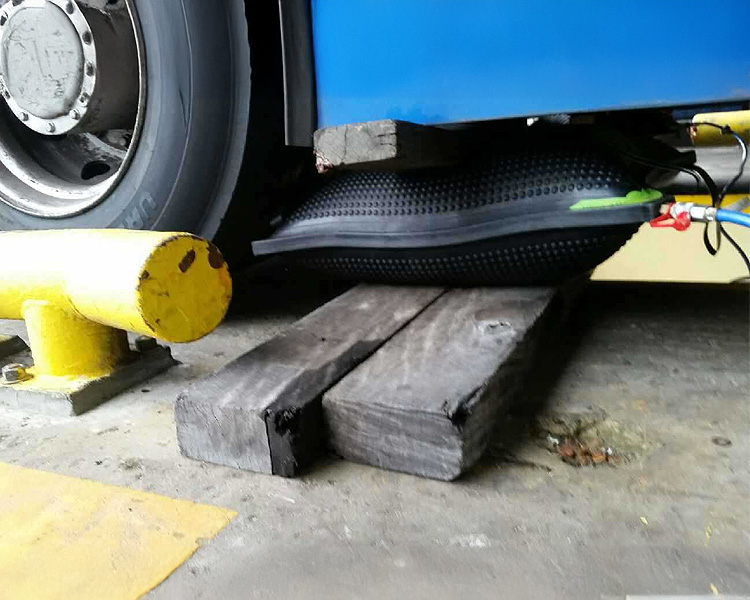 Simplex airbag lifting the corner of a bus for repair operations.